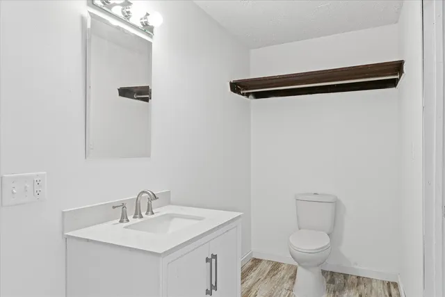 a bathroom with a granite countertop sink toilet and a mirror