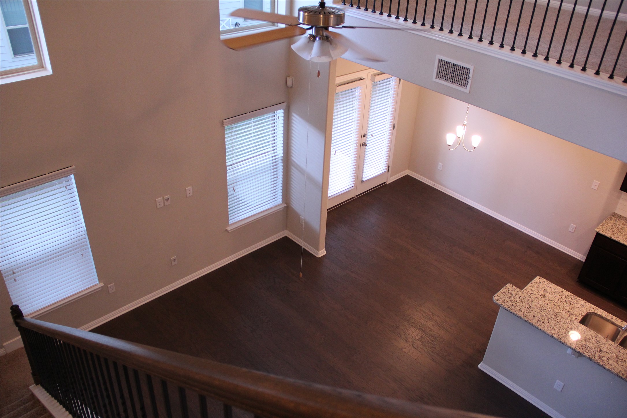 1612 Airedale Road Austin, TX 78748 - Photo 7 of 26 Unfurnished living room featuring a high ceiling, plenty of natural light, a ceiling fan, hanging lights, and dark wood-style floors