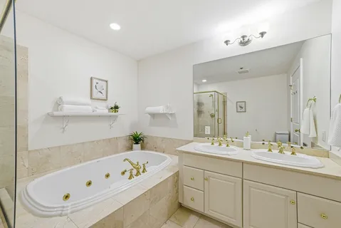a bathroom with a tub a sink and mirror