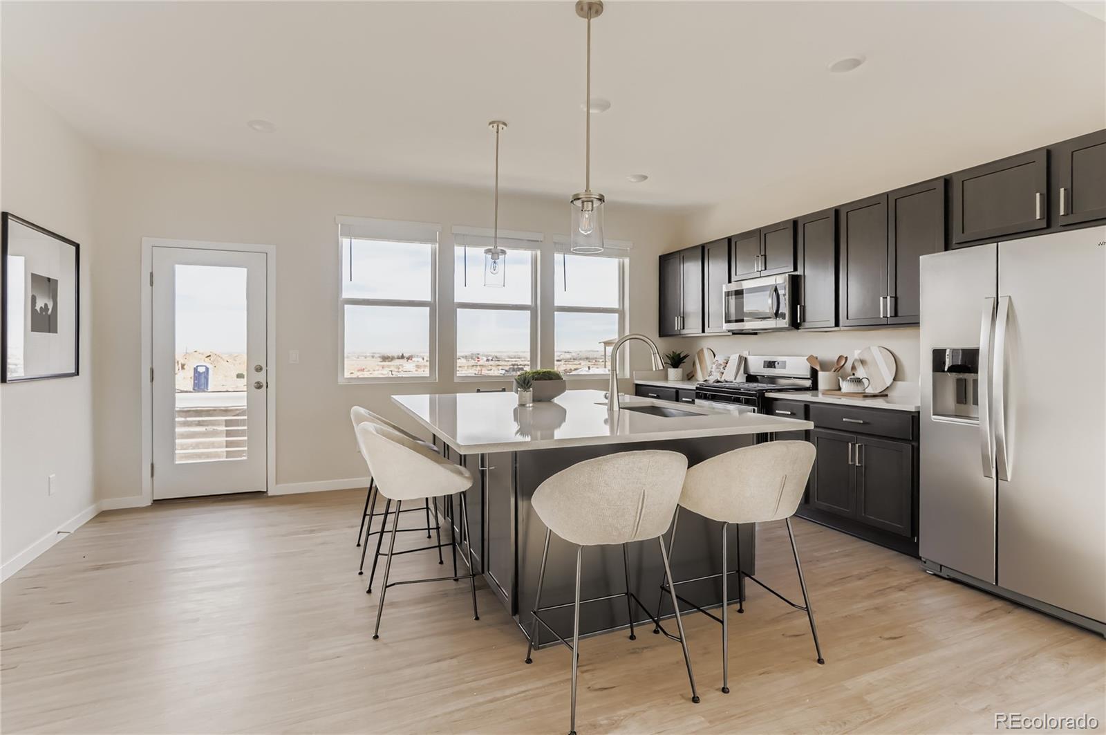 13342 Front Porch Firestone, CO 80504 - Photo 11 of 27 a kitchen with stainless steel appliances granite countertop a dining table chairs refrigerator sink and cabinets