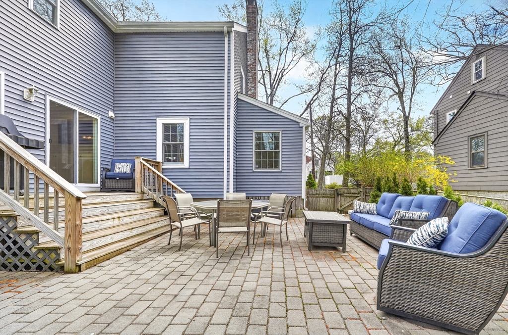 87 Payson Road Brookline, MA 02467 - Photo 37 of 41 a view of a patio with dining table and chairs with wooden floor and fence