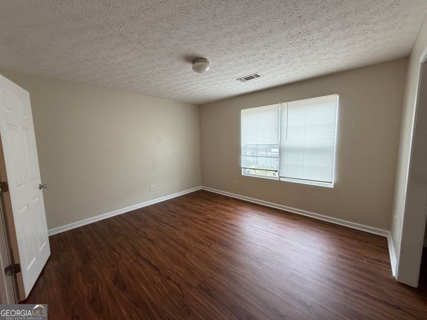 5196 Tew Lane Southwest Covington, GA 30014 - Photo 23 of 41 an empty room with wooden floor and windows