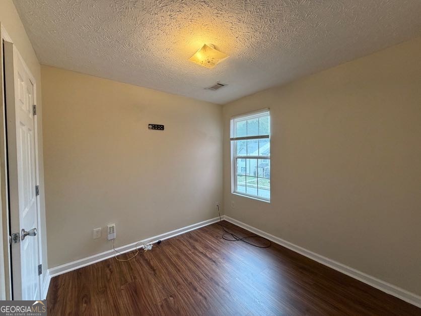 5196 Tew Lane Southwest Covington, GA 30014 - Photo 25 of 41 an empty room with wooden floor and windows