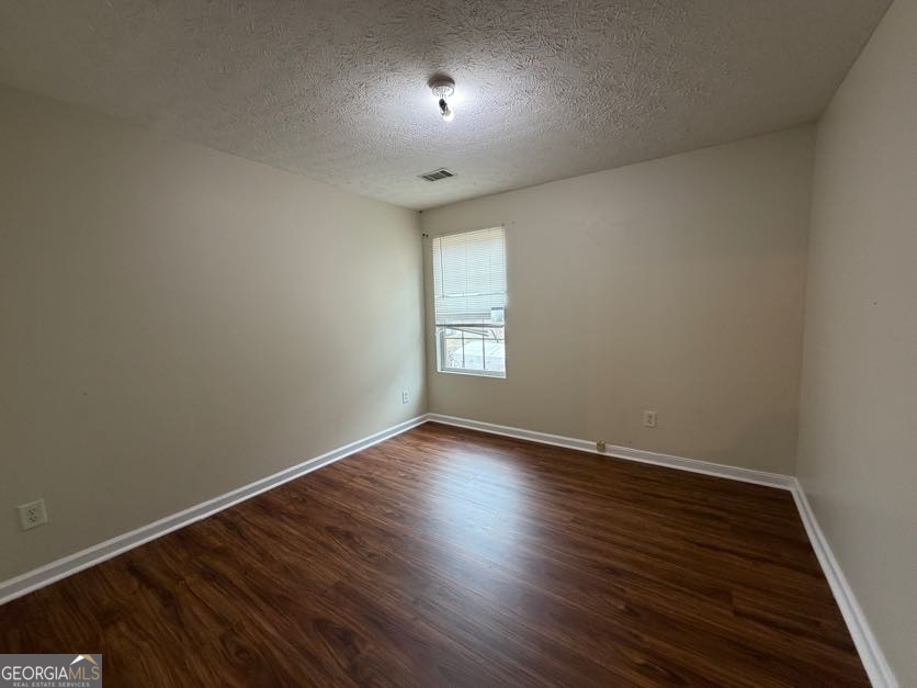 5196 Tew Lane Southwest Covington, GA 30014 - Photo 29 of 41 an empty room with wooden floor and windows
