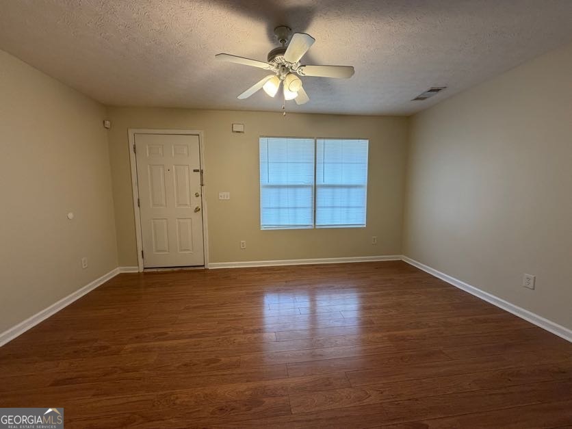 5196 Tew Lane Southwest Covington, GA 30014 - Photo 3 of 41 an empty room with wooden floor chandelier fan and windows