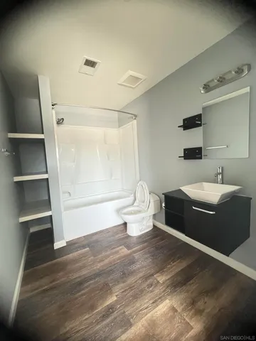 a bathroom with a sink a toilet and shower