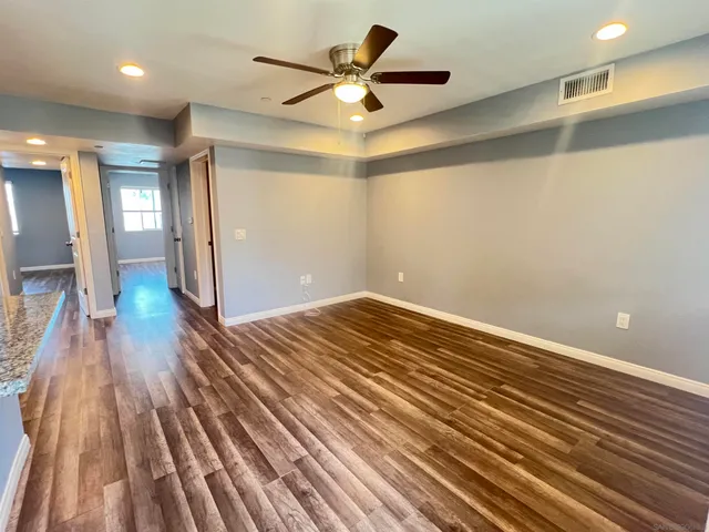 a view of empty room with wooden floor