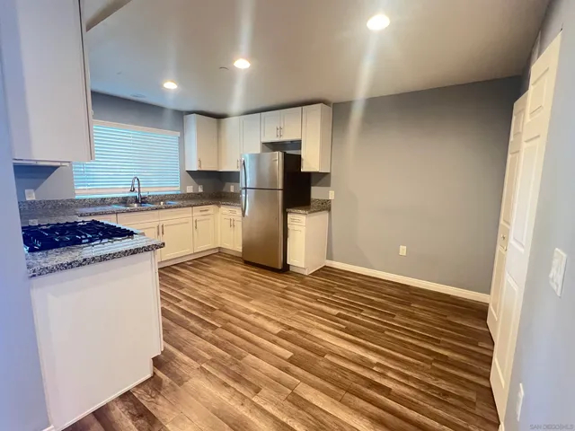 a kitchen with a refrigerator and a stove top oven