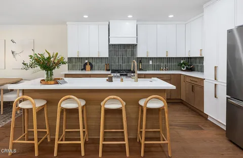 a kitchen with granite countertop a sink and white cabinets