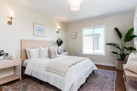 a bedroom with bed plant and window