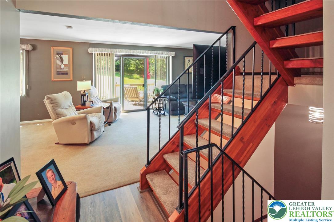 3470 Brodhead Road Bethlehem, PA 18020 - Photo 35 of 84 A striking wooden staircase with wrought iron accents creates a grand entry to the sun-filled living area.