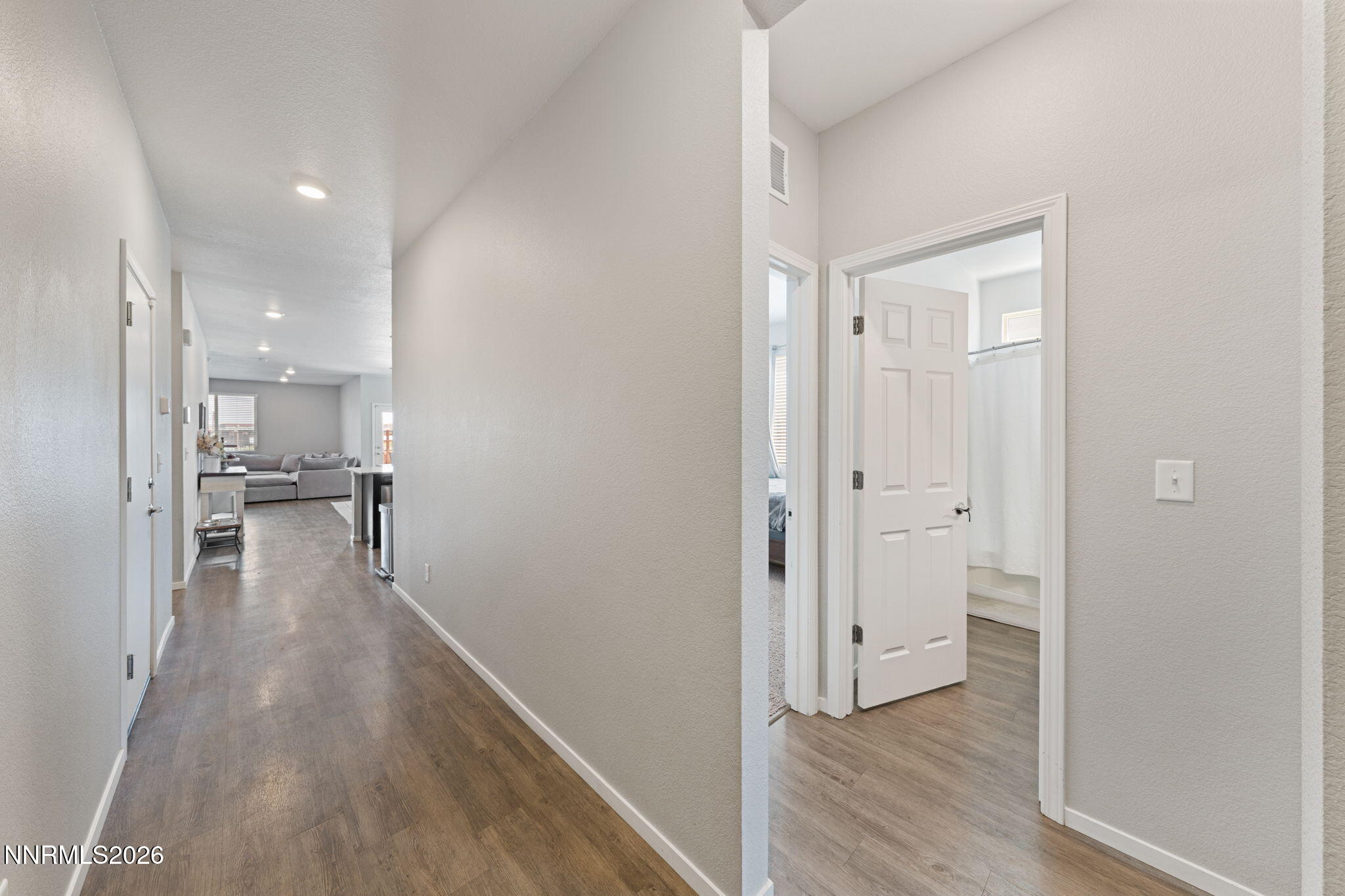9708 Sea Glass Drive Reno, NV 89506 - Photo 4 of 51 a view of a hallway with wooden floor and a kitchen