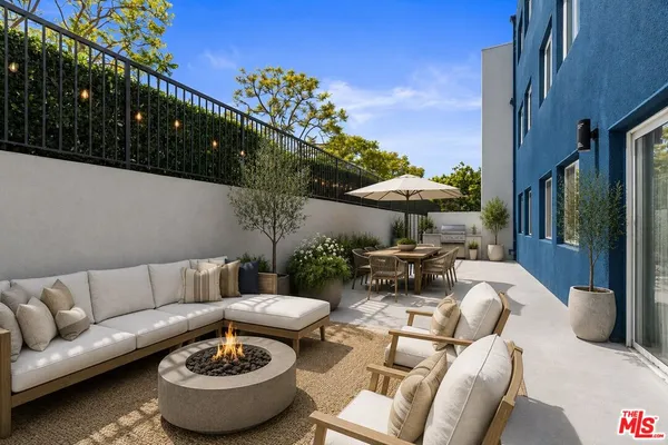 a view of a patio with couches table and chairs and potted plants
