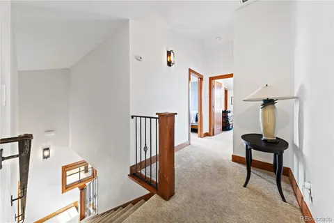 a view of a hallway with furniture and entryway with wooden floor