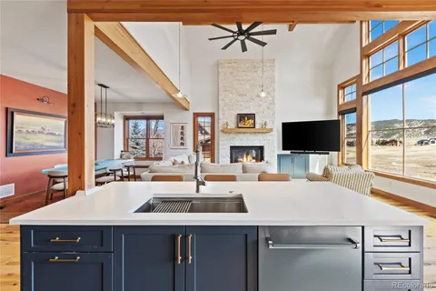 a view of a kitchen with kitchen island a sink appliances and a counter top space