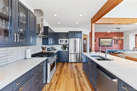 a kitchen with stainless steel appliances granite countertop sink stove refrigerator and cabinets