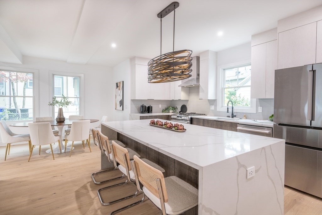 a large kitchen with kitchen island a stove a sink a dining table and chairs