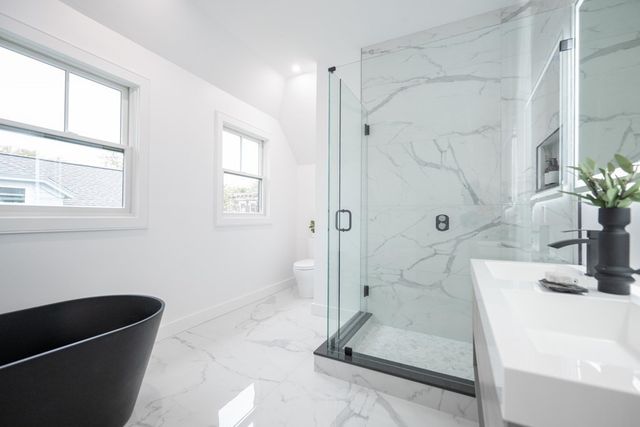 a bathroom with a tub shower and window