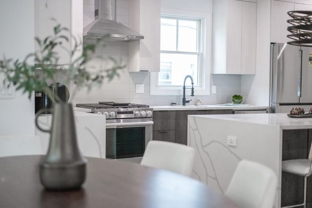 a kitchen with stainless steel appliances a white stove top oven a sink a counter space and a window