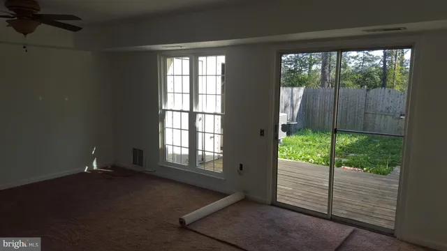 an empty room with wooden floor and a window