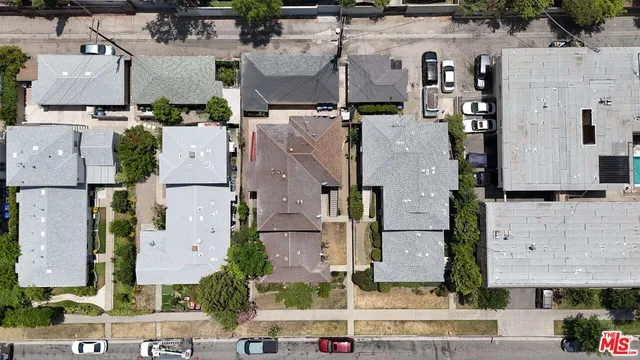 an aerial view of residential houses with outdoor space and parking