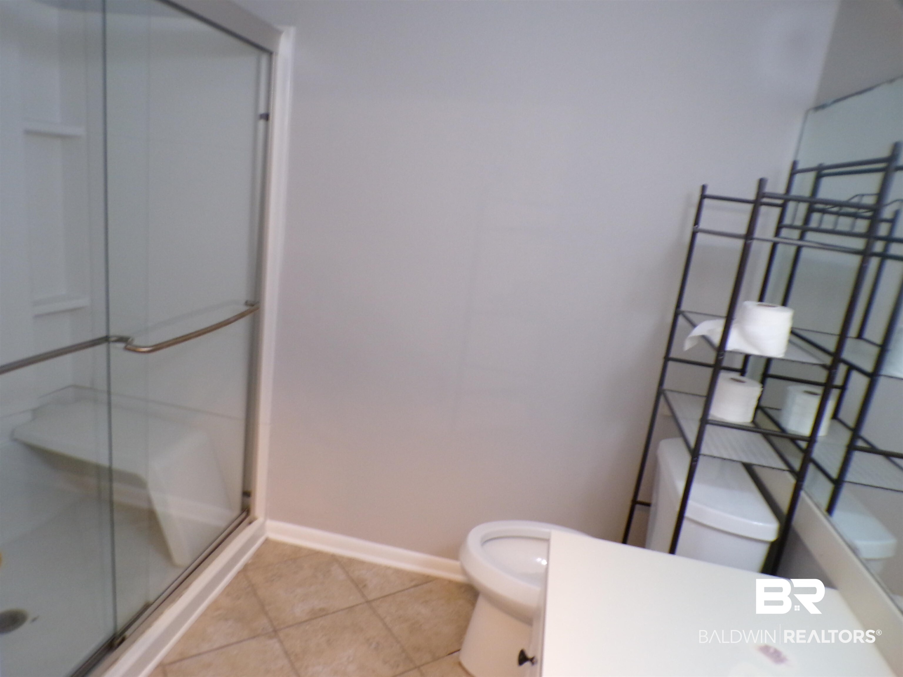 1152 North Alston Street, Unit 1152 Foley, AL 36535 - Photo 16 of 16 Bathroom featuring a glass-enclosed shower with an integrated bench, neutral wall paint, and tiled flooring