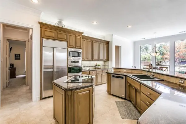 a kitchen with stainless steel appliances granite countertop a stove refrigerator and sink