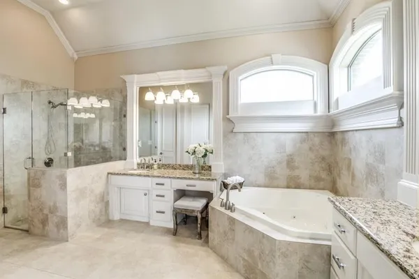 a bathroom with a granite countertop tub a sink and a mirror