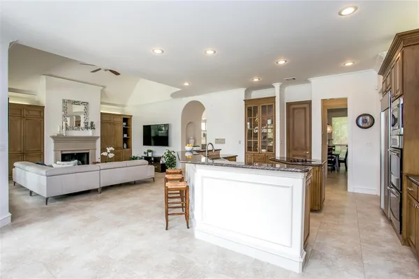 a large white kitchen with a large window and refrigerator