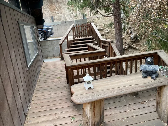 a view of a balcony with wooden floor and outdoor seating