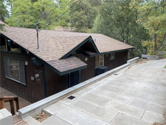 a backyard of a house with wooden deck and furniture