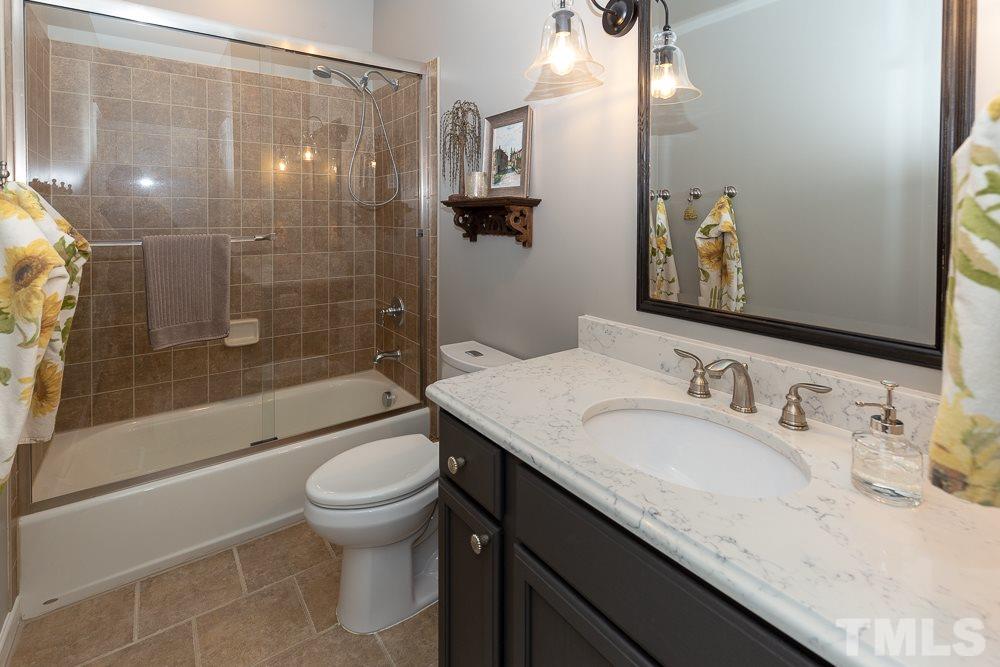 2924 Sunnystone Way Raleigh, NC 27613 - Photo 12 of 30 a bathroom with a granite countertop sink a toilet and shower