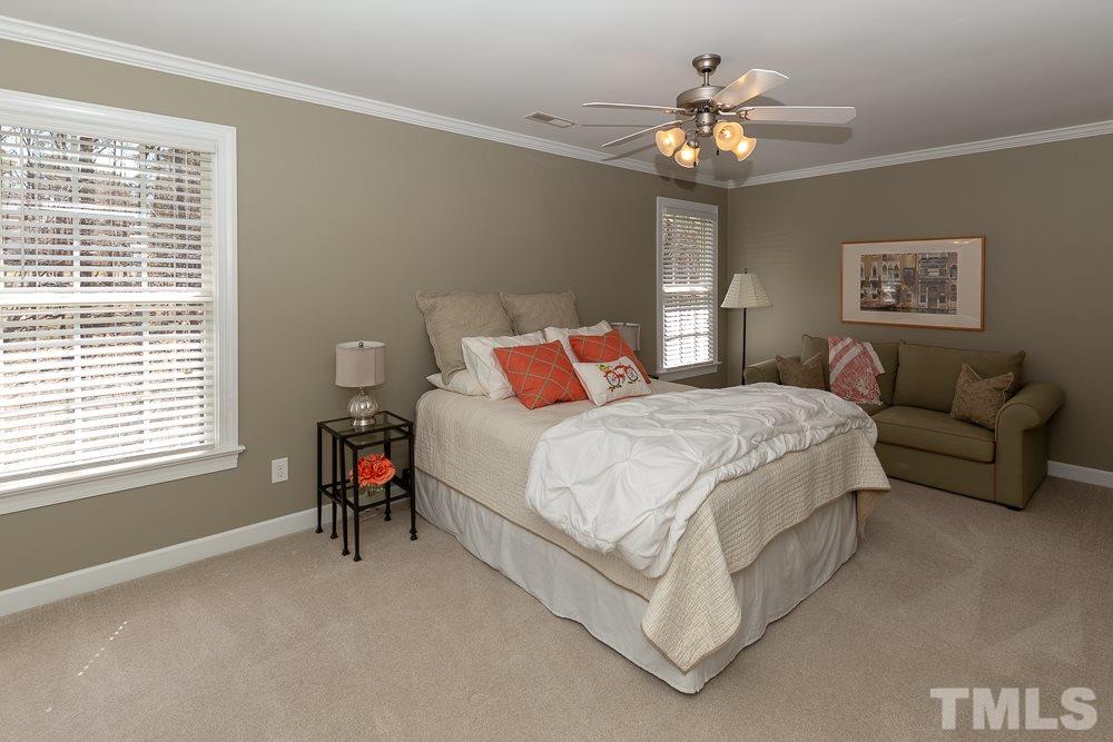 2924 Sunnystone Way Raleigh, NC 27613 - Photo 17 of 30 a bedroom with a bed and a chandelier