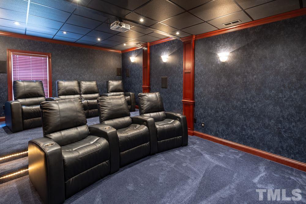 2924 Sunnystone Way Raleigh, NC 27613 - Photo 24 of 30 a media room with lots of chairs and a projector screen