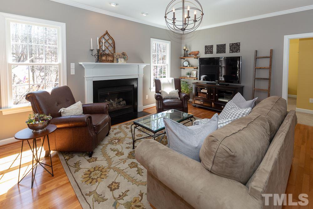 2924 Sunnystone Way Raleigh, NC 27613 - Photo 4 of 30 a living room with furniture a fireplace and a flat screen tv