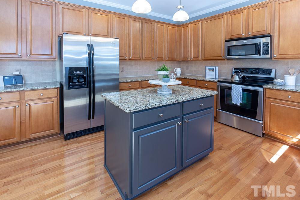 2924 Sunnystone Way Raleigh, NC 27613 - Photo 8 of 30 a kitchen with stainless steel appliances granite countertop a refrigerator stove top oven a sink and dishwasher with wooden floor