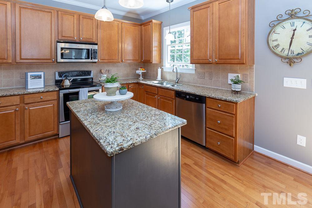 2924 Sunnystone Way Raleigh, NC 27613 - Photo 9 of 30 a kitchen with granite countertop a stove a sink dishwasher and cabinets with wooden floor