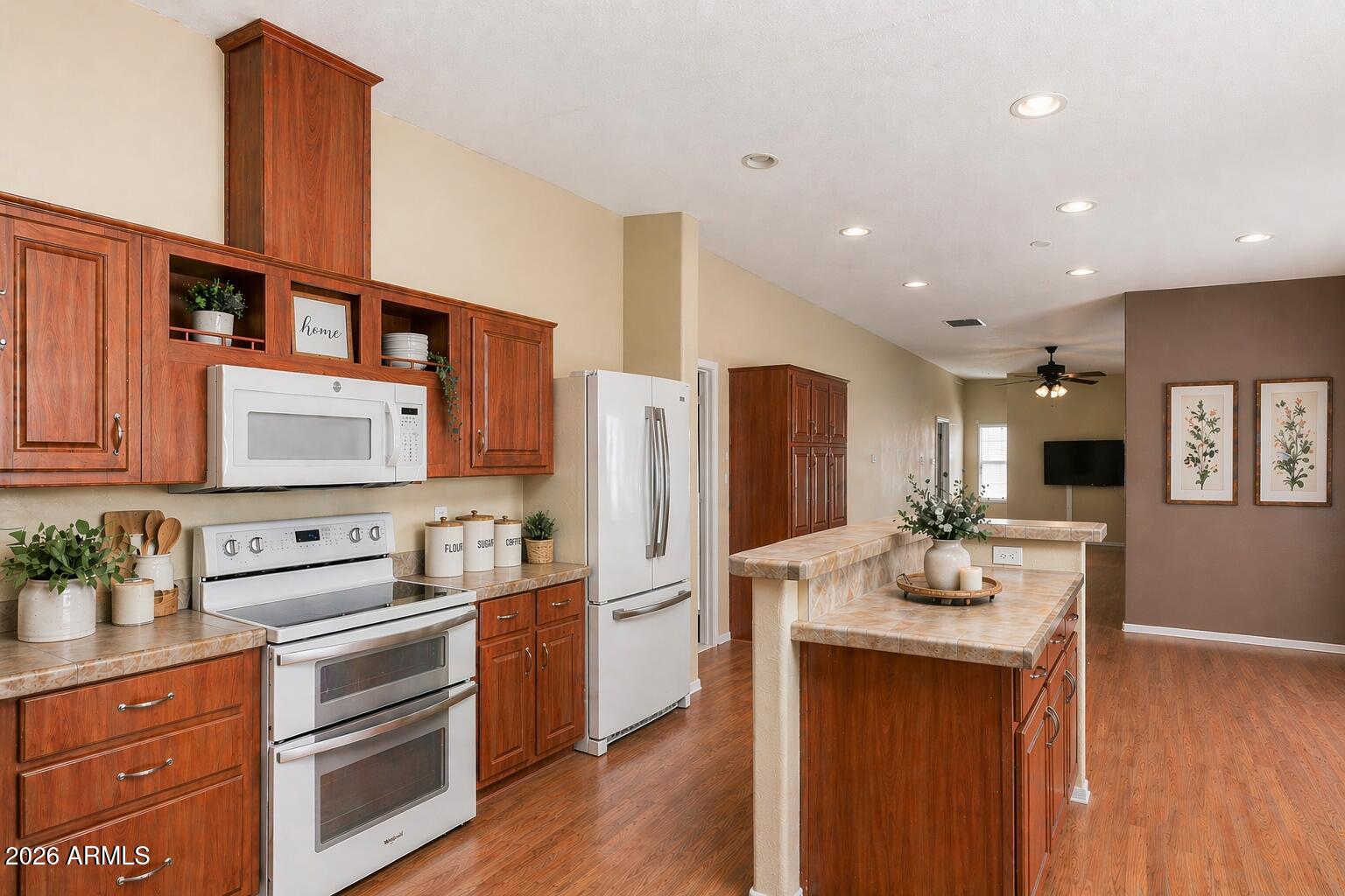 23851 West Tether Trail Wittmann, AZ 85361 - Photo 15 of 44 a kitchen with refrigerator cabinets and wooden floor