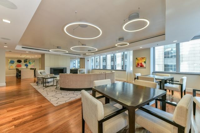 a dining hall with couches a table and chairs with wooden floor
