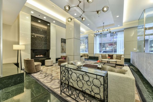 a kitchen with stainless steel appliances granite countertop a sink dishwasher a stove a dining table and chairs with wooden floor