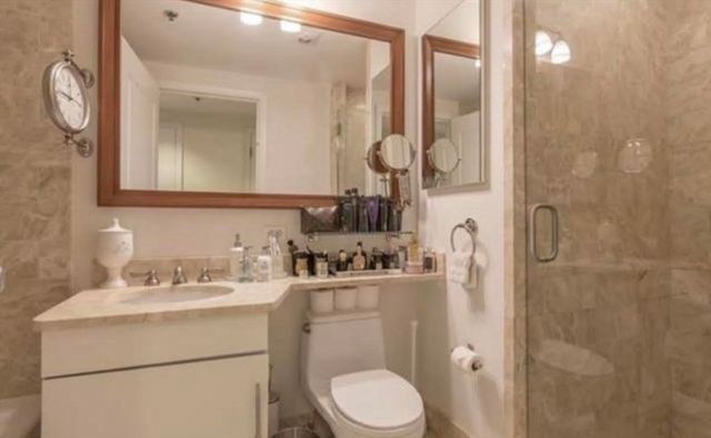 a bathroom with a sink vanity granite toilet and a mirror