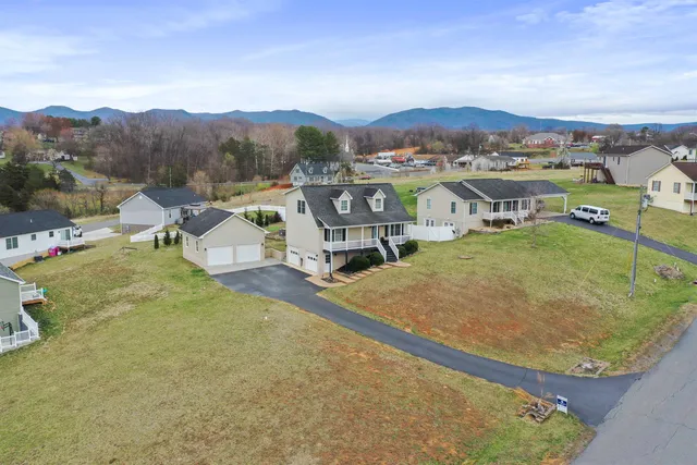 an aerial view of a house with a mountain