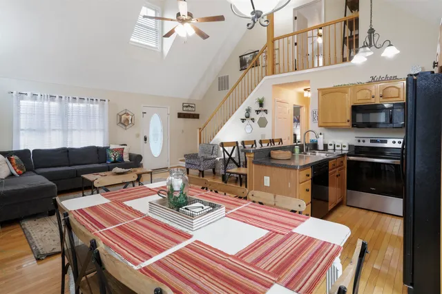 a living room with furniture a flat screen tv and kitchen view