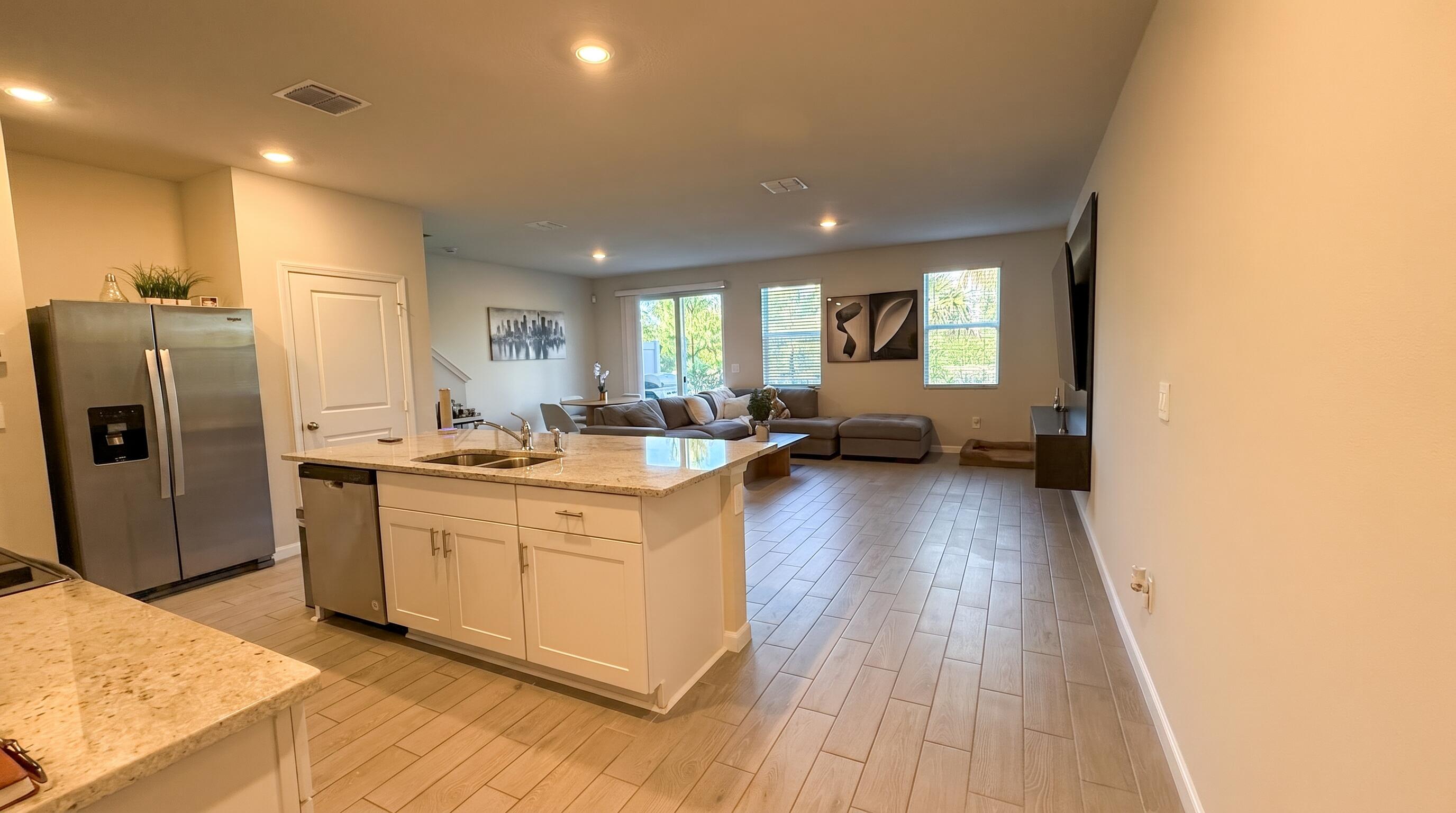 5784 Southeast Edgewater Circle Stuart, FL 34997 - Photo 2 of 33 a kitchen with stainless steel appliances granite countertop a refrigerator a sink dishwasher a stove and white countertops with wooden floor