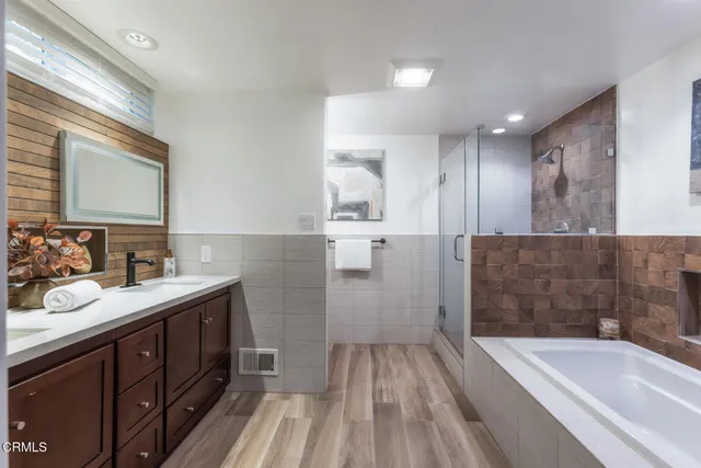 a bathroom with a tub a shower and view