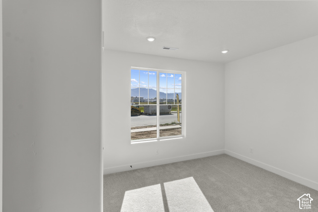 205 East 690th Street North Logan, UT 84321 - Photo 5 of 52 Recessed lighting illuminates this bright room featuring a window with grid patterns, light-toned carpeting, and crisp white walls