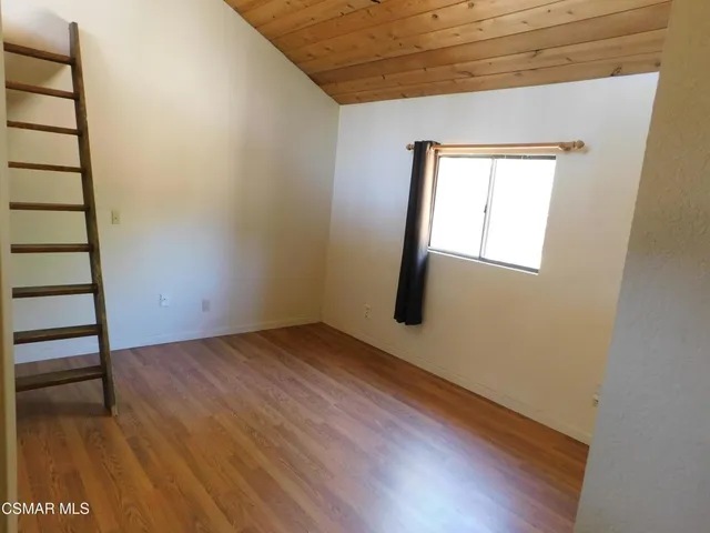 a view of a hallway with wooden floor and a window