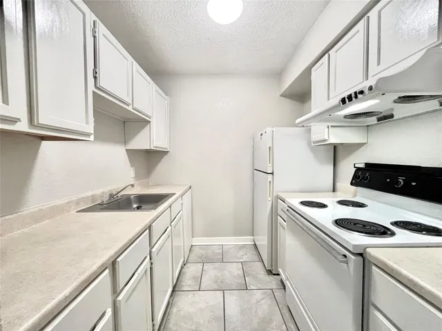 a kitchen with a stove and a white cabinets