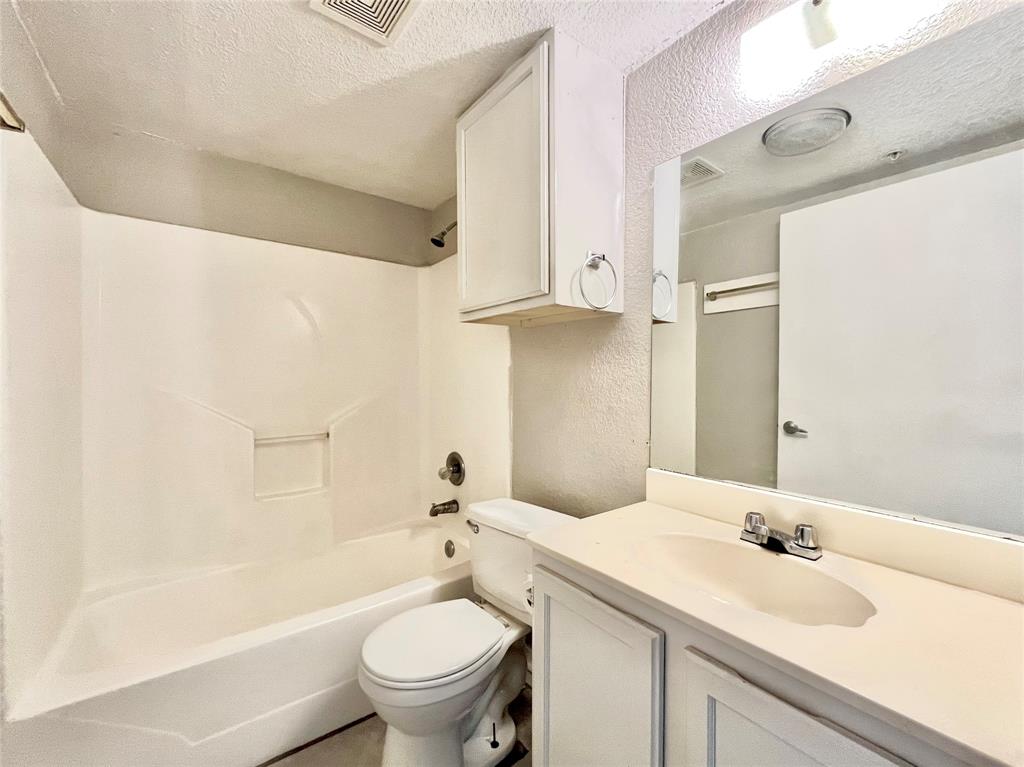 701 West Sycamore Street, Unit 107 Denton, TX 76201 - Photo 5 of 11 a bathroom with a granite countertop sink toilet and shower