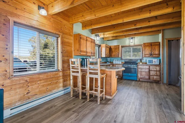 a view of a kitchen with furniture and wooden floor